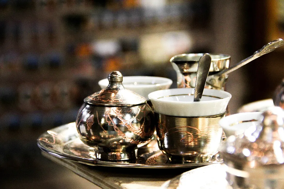 A Bosnian coffee set with a copper dzezva pot and a small fildzan cup on a tray
