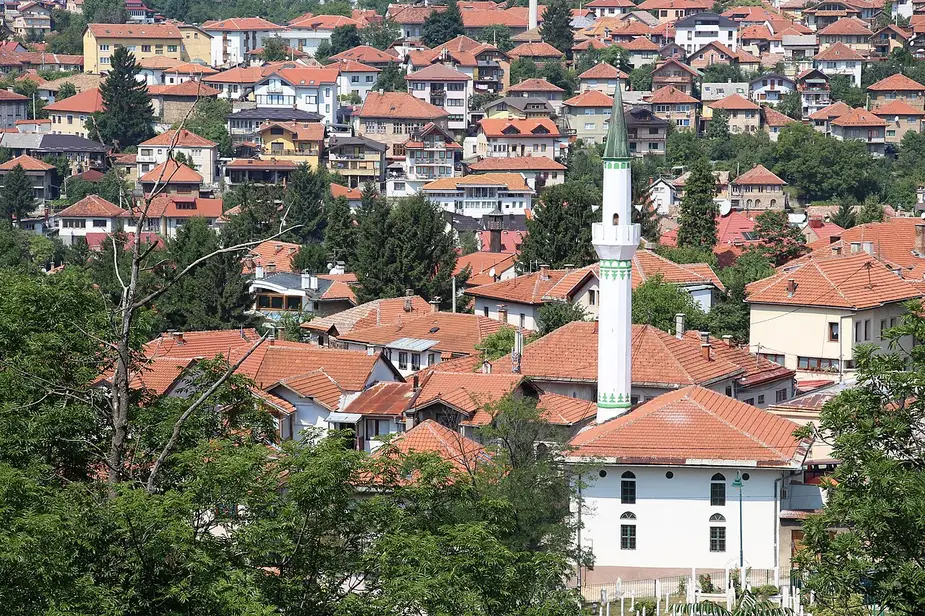 A view over the red-tiled rooftops and a white minaret of Sarajevo old town from the hillside near the Yellow Bastion