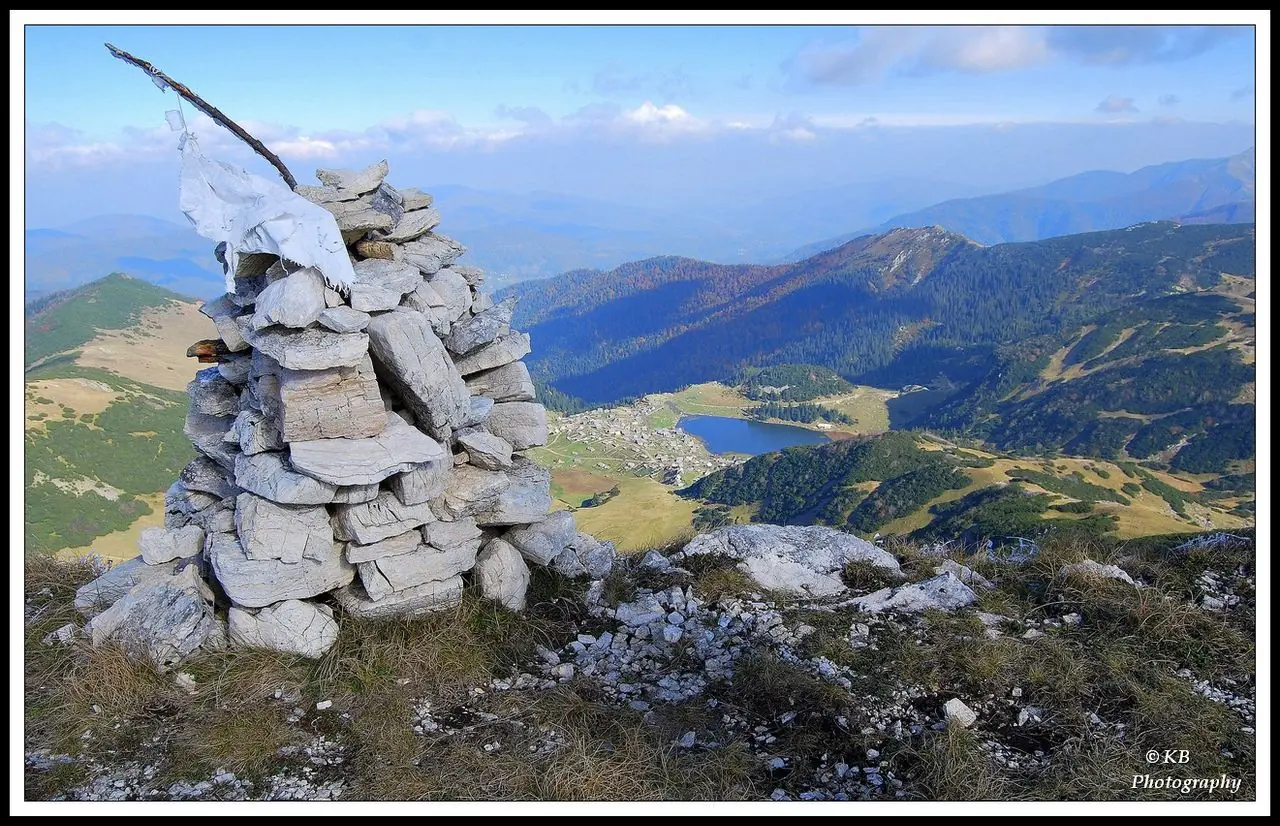 Prokoško Lake in a high pasture bowl on Vranica with wooden shepherd huts nearby