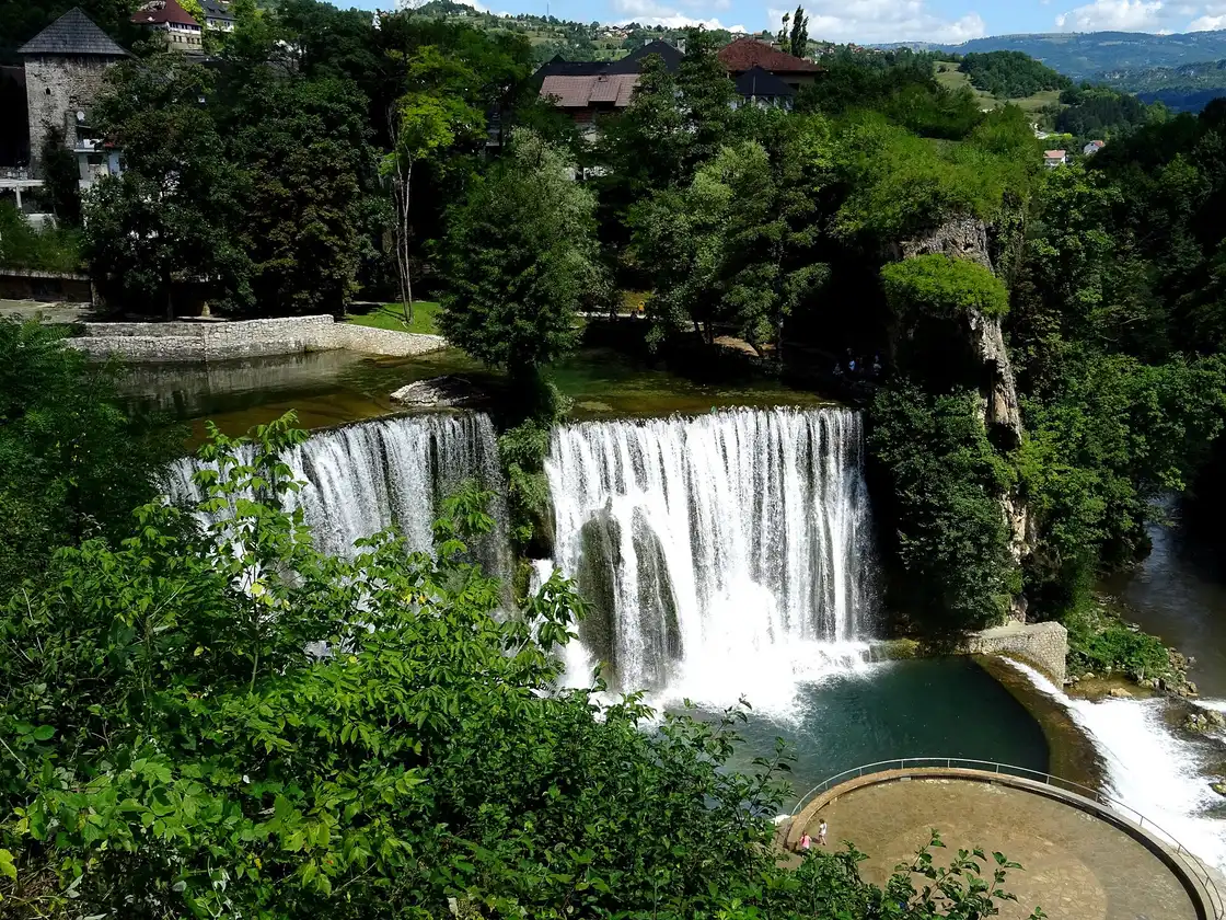 The Pliva waterfall pouring over a tufa ledge in the centre of Jajce with the old town behind