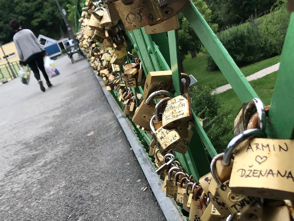 The footbridge above the Pliva waterfall in Jajce, its railings hung with lovers padlocks