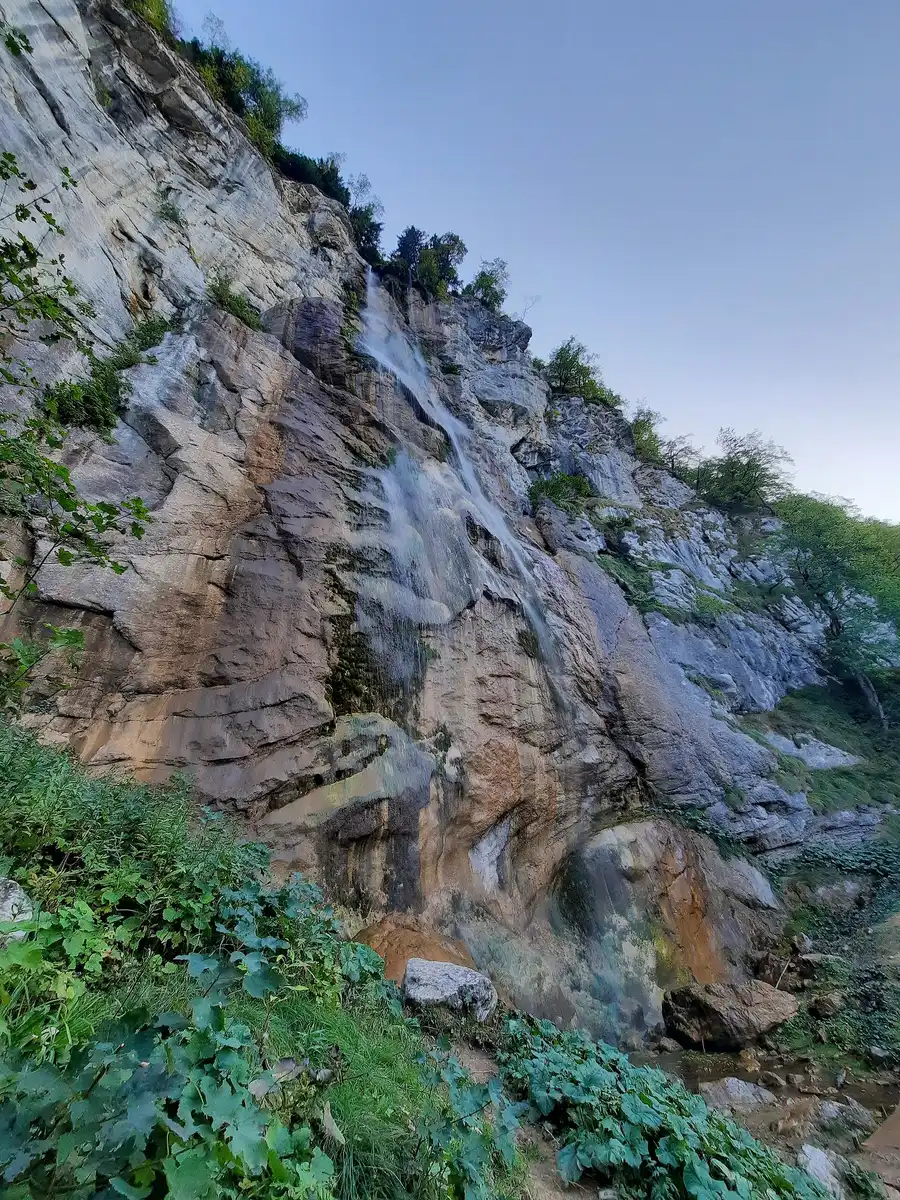 The tall, thin free-falling column of Skakavac waterfall dropping through forest north of Sarajevo
