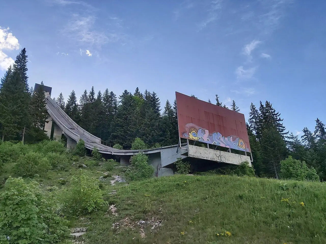 The derelict concrete in-run of the K-112 Olympic ski jump at Malo Polje on Igman, covered in graffiti
