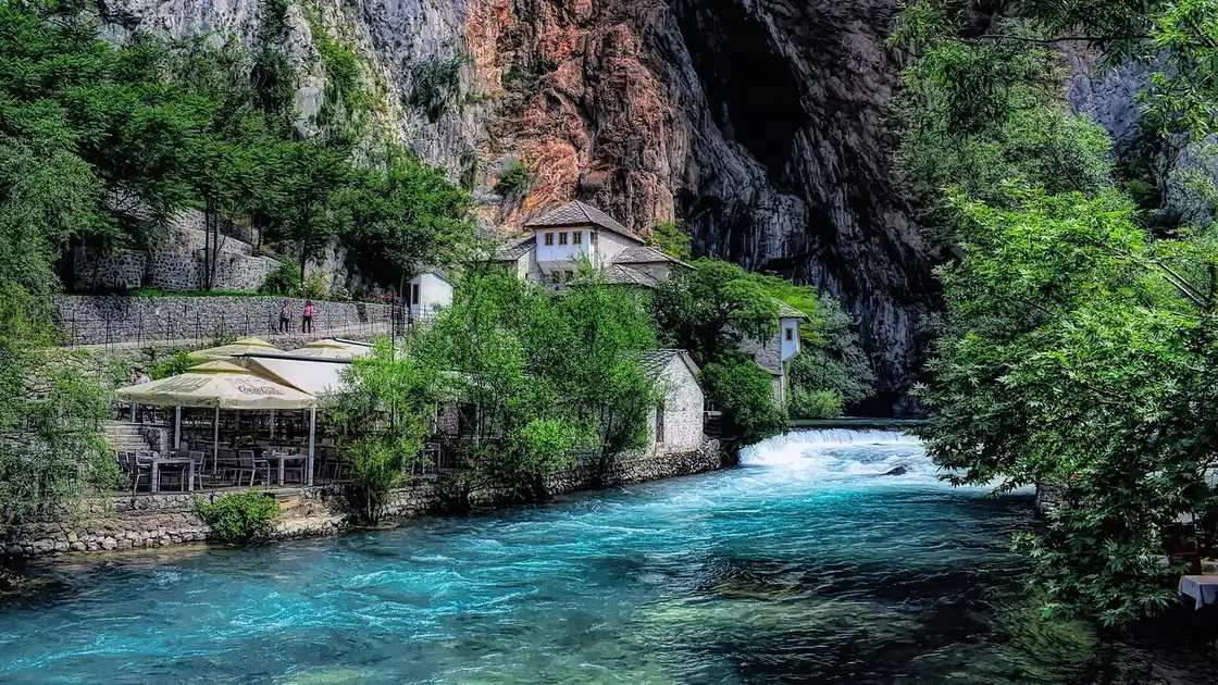 The white Blagaj Tekke dervish house tucked under a sheer limestone cliff beside the clear green Buna river