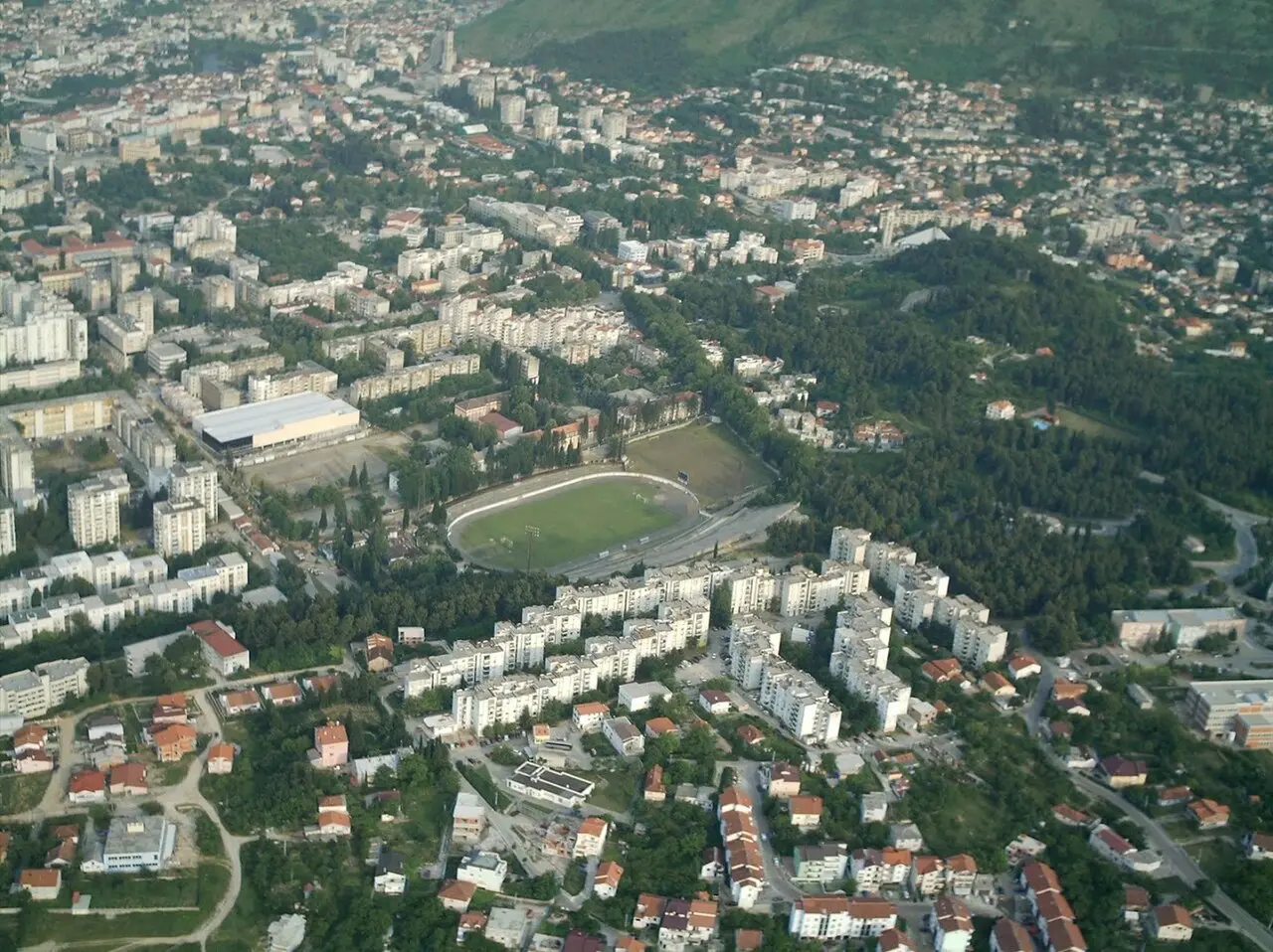 Aerial view of Mostar with the Old Bridge over the Neretva, minarets and terracotta rooftops spread along the river