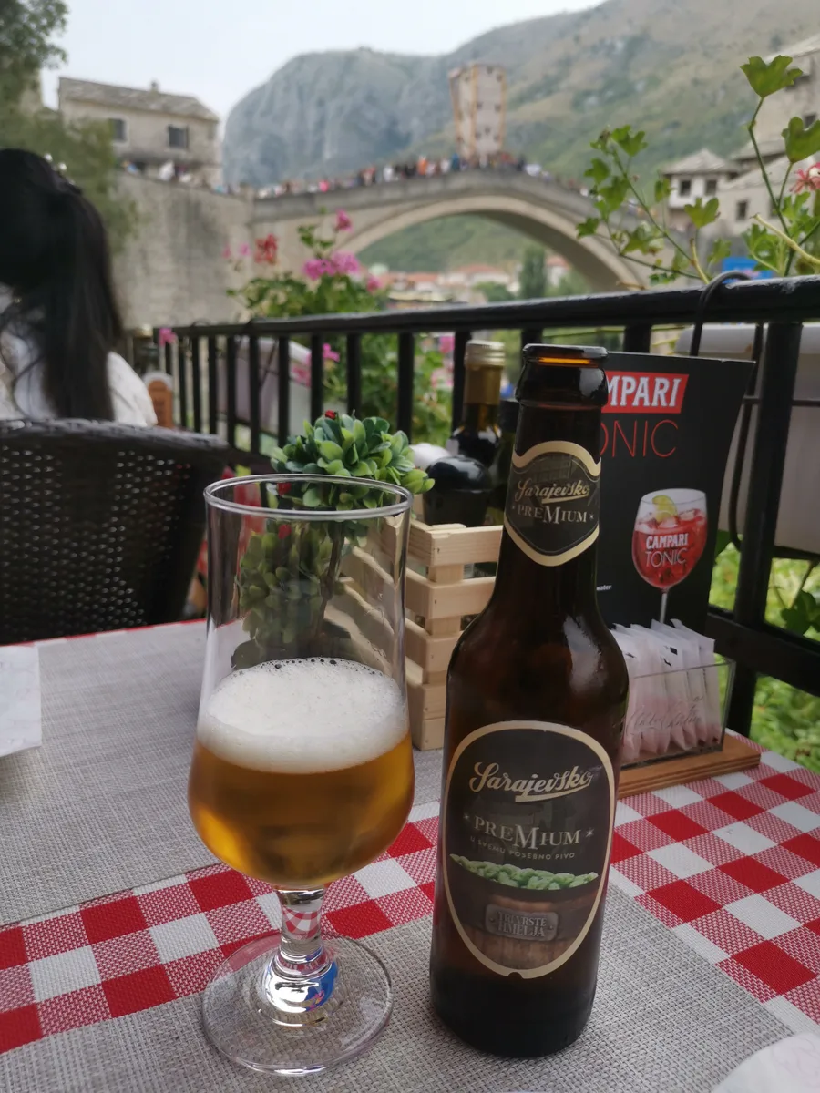 A bottle and glass of Sarajevsko beer on a café terrace table above the Old Bridge in Mostar