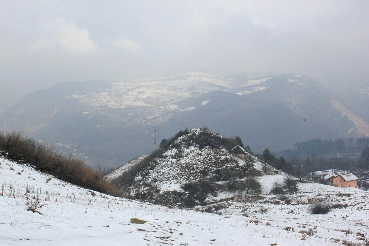 A snow-covered Bosnian hillside and misty mountains near Sarajevo in mid-winter