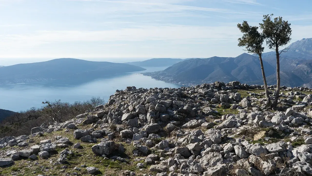 The Bay of Kotor seen from the Vrmac ridge, blue water folded between steep grey mountains under a clear sky