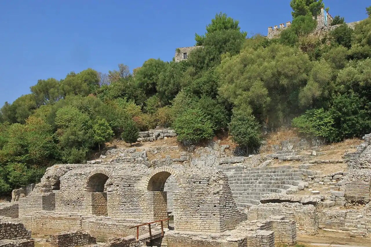 Stone seats of the ancient theatre at Butrint with the Venetian fortress above the lagoon