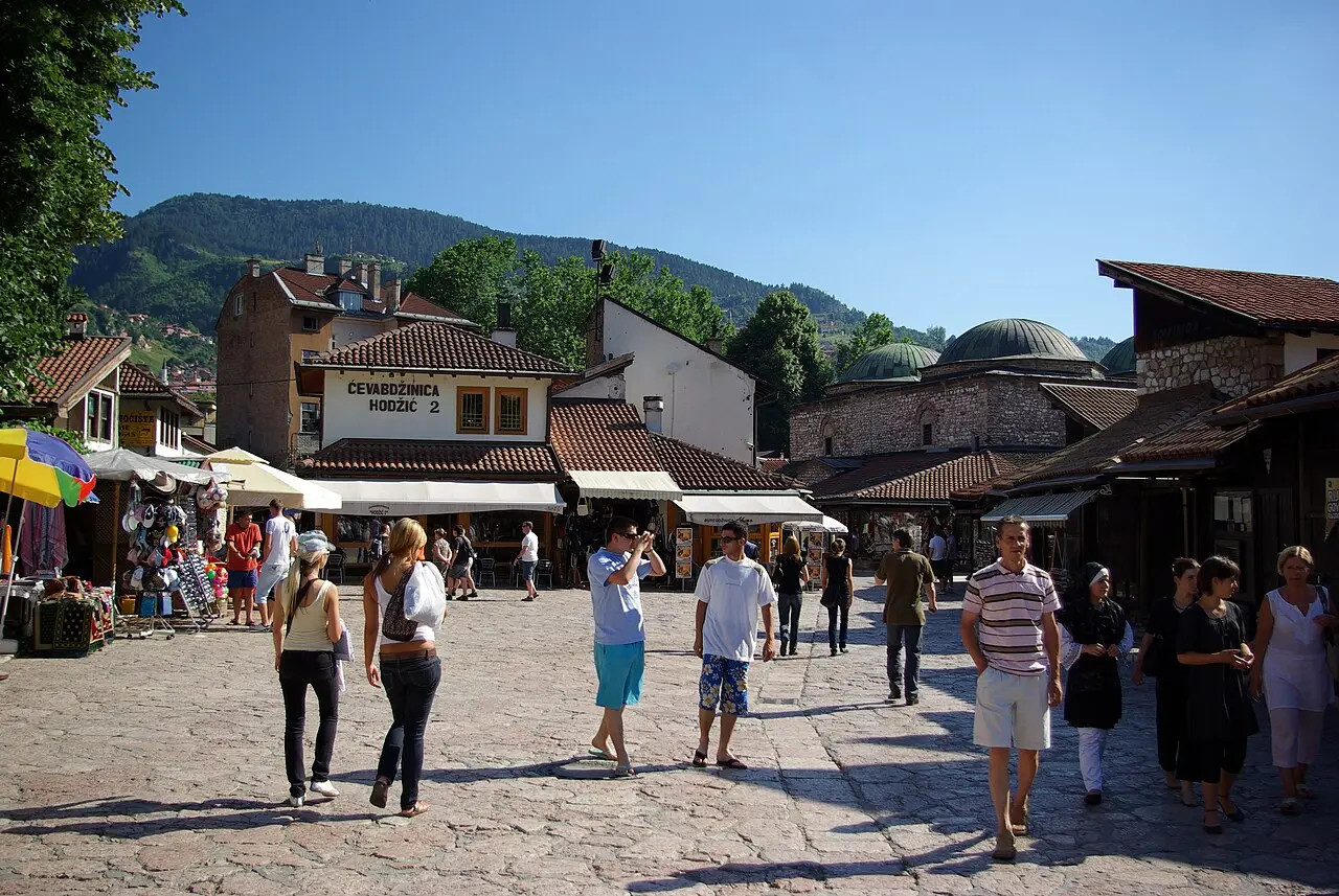 The Ottoman old town of Sarajevo with minarets, tiled roofs and green hills rising behind