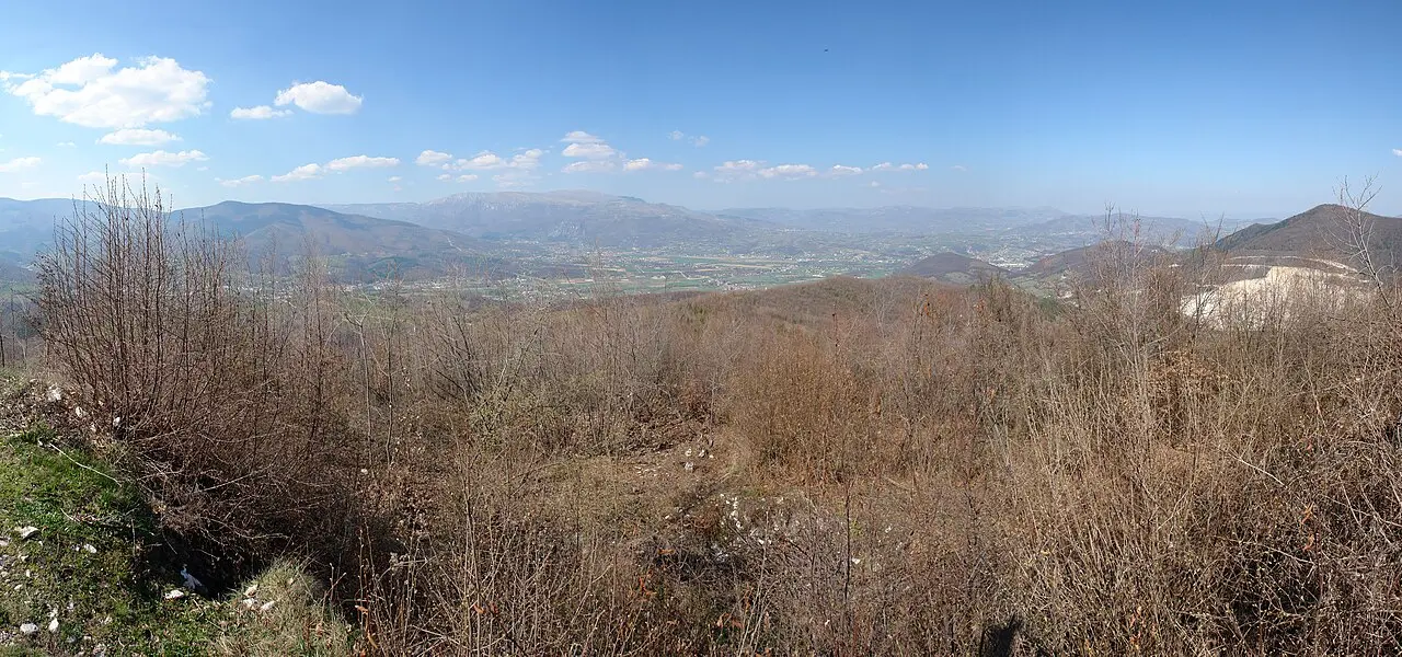 The wide green Lašva valley west of Travnik, fields and a river under a long wooded ridge, the road home to Sarajevo