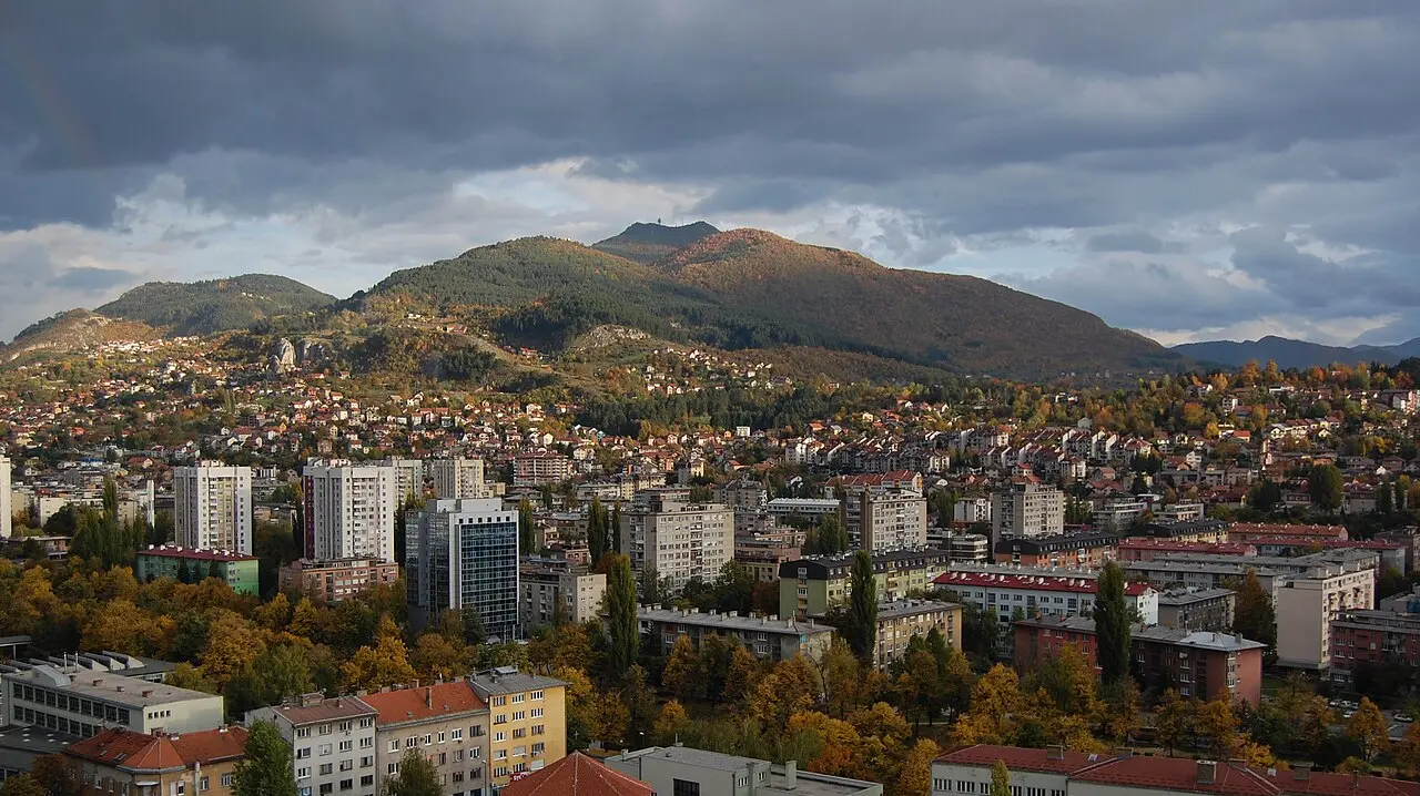 The residential hillsides of Sarajevo packed with houses rising above the valley on a clear day