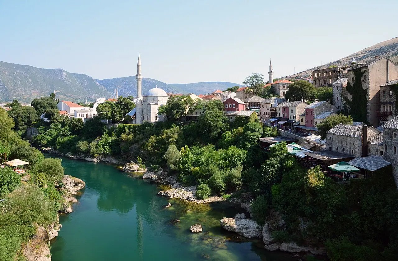 The town of Mostar spread along the green Neretva river beneath the surrounding hills