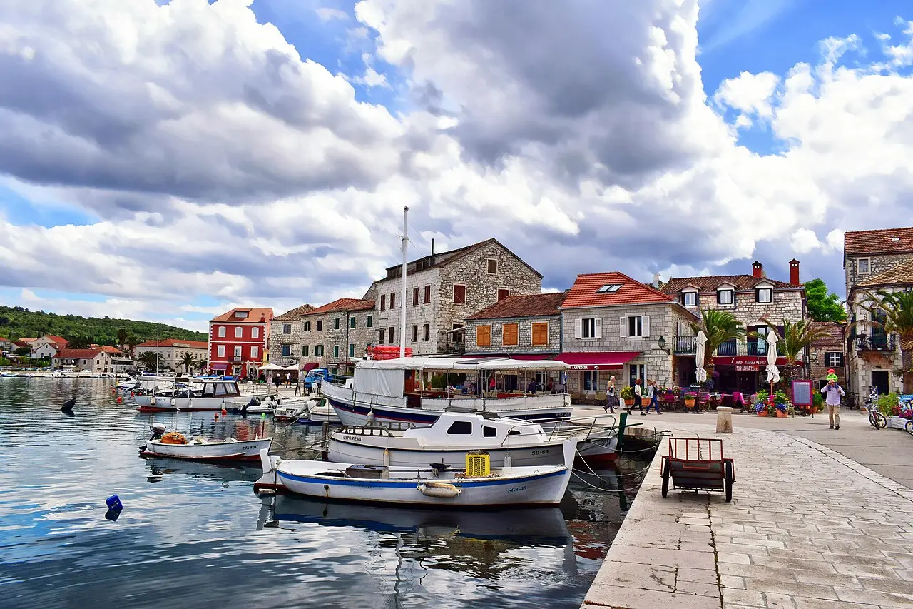 Fishing boats moored along the stone waterfront of Stari Grad on the Croatian island of Hvar under a cloudy sky
