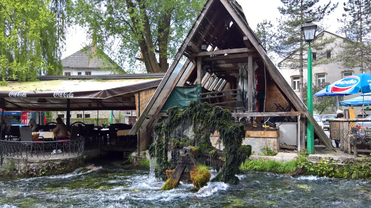 The blue-green water of Plava Voda in Travnik running past an old stone watermill