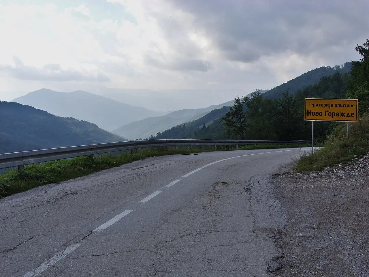 A green road sign in Republika Srpska with the place name written in Cyrillic script