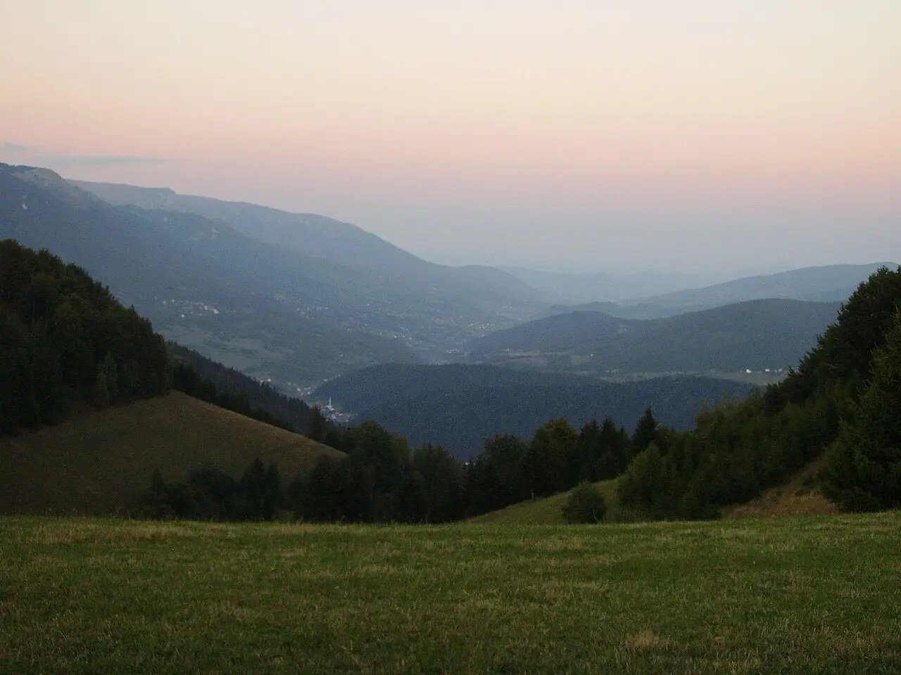 A road climbing over the Karaula pass with a wide view down into the wooded Lašva valley in central Bosnia
