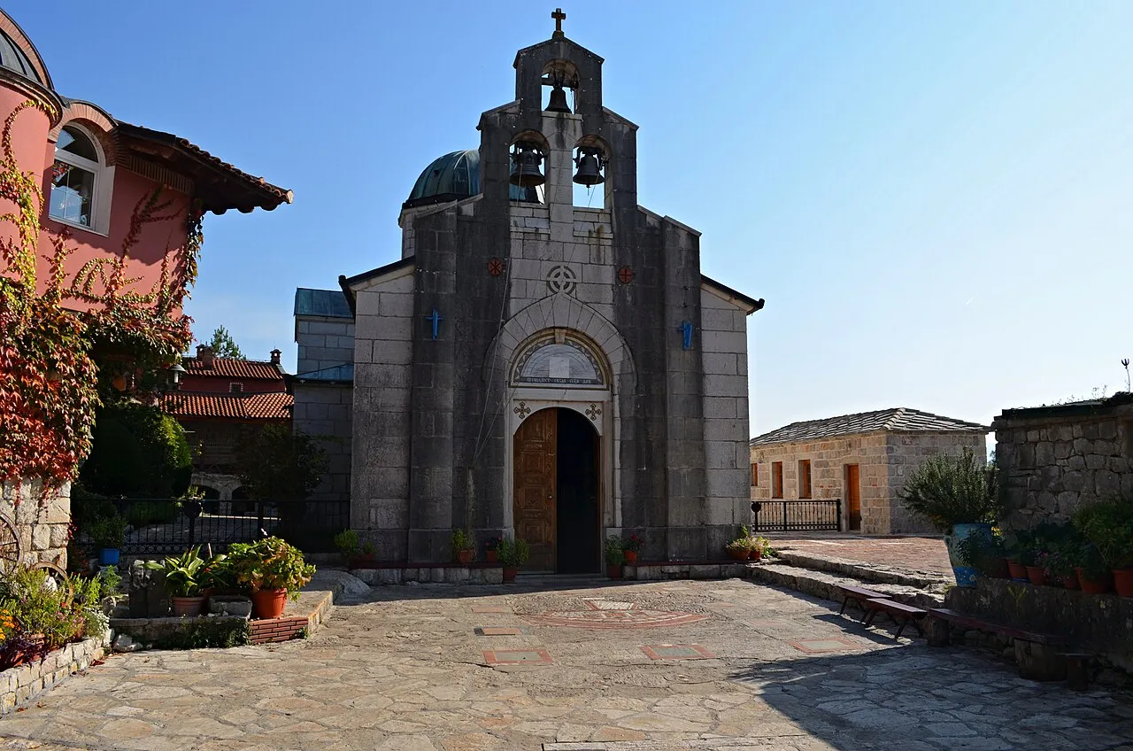 The pale stone church of Tvrdos Monastery near Trebinje with its triple bell wall, a working Orthodox monastery known for its wine cellars
