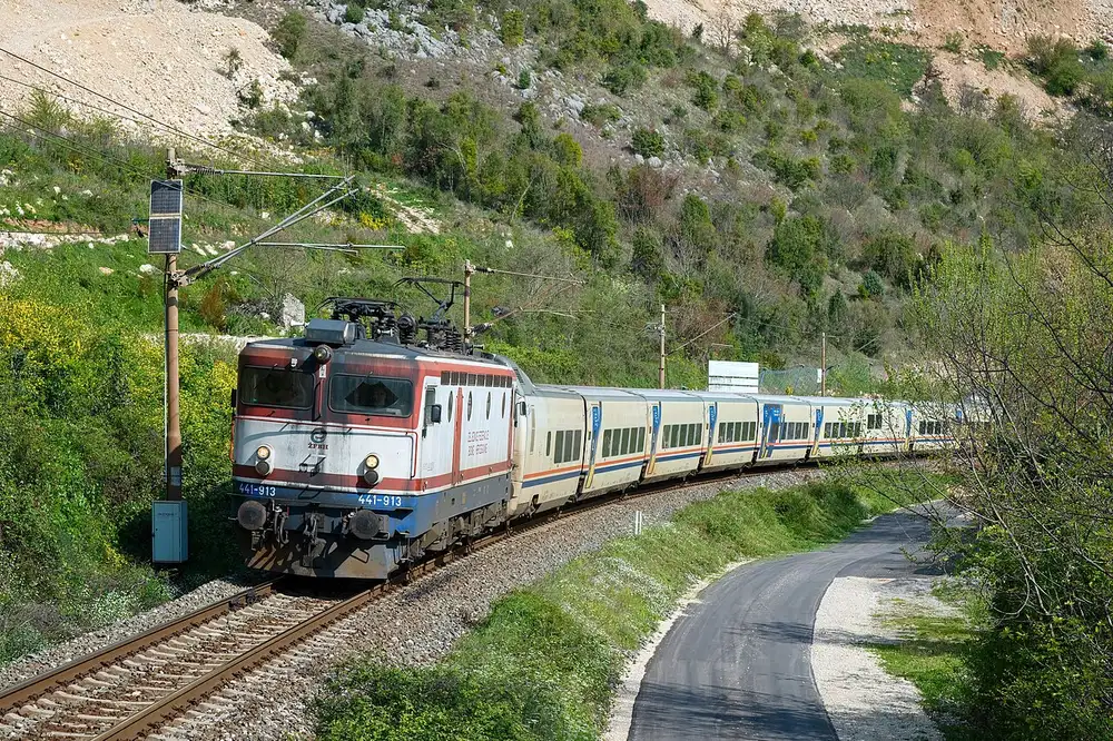 A blue ŽFBH locomotive hauling the Neretva-valley line near Surmanci south of Mostar towards Čapljina