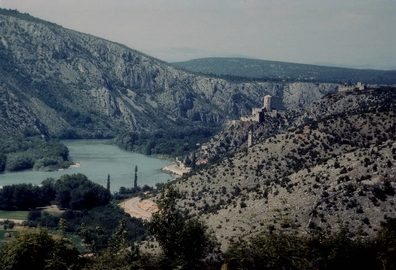 The Neretva river valley near Počitelj, green water winding between karst hills with the Ottoman hilltop town above