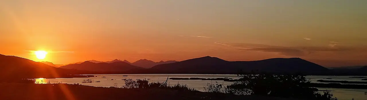 Sunset over the flooded lakes of Hutovo Blato, the sun dropping behind a line of dark hills