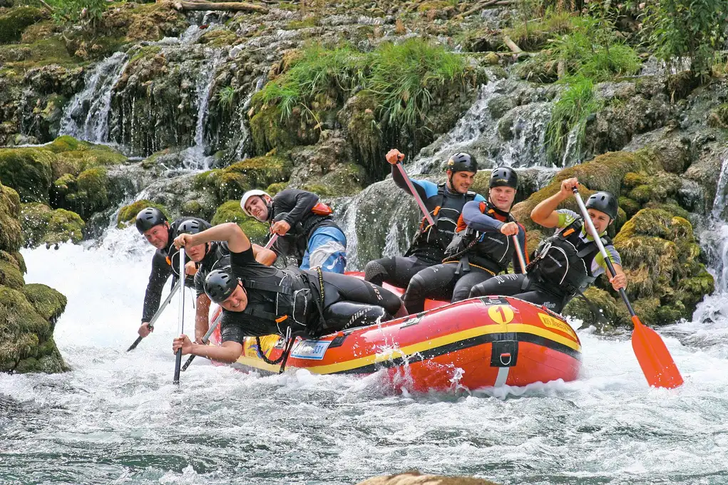 A raft of paddlers working through white water on the emerald Una river in northwest Bosnia