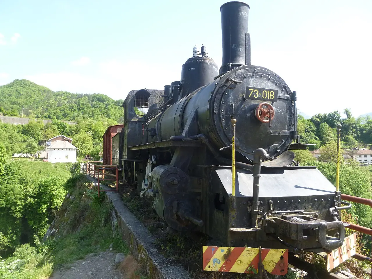 Narrow-gauge locomotive on a plinth among the outdoor exhibits at the Jablanica memorial complex