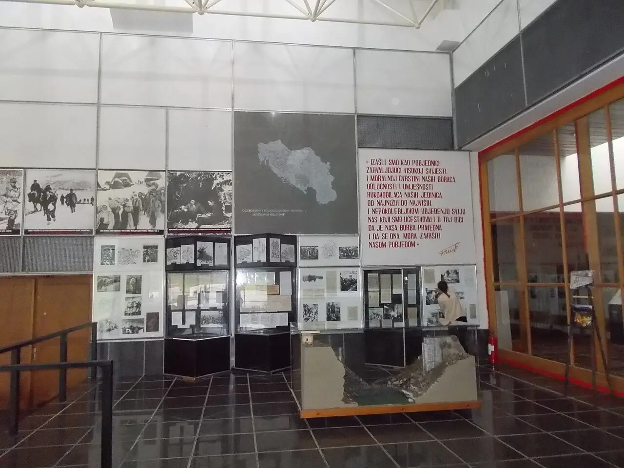 Interior exhibition hall of the Battle of the Neretva museum with display cases and wall panels