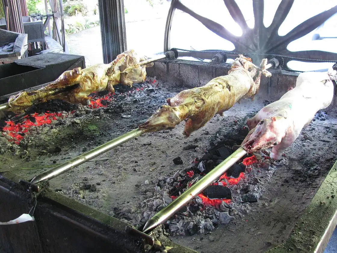 Whole lamb roasting on a spit at a roadside grill in Jablanica