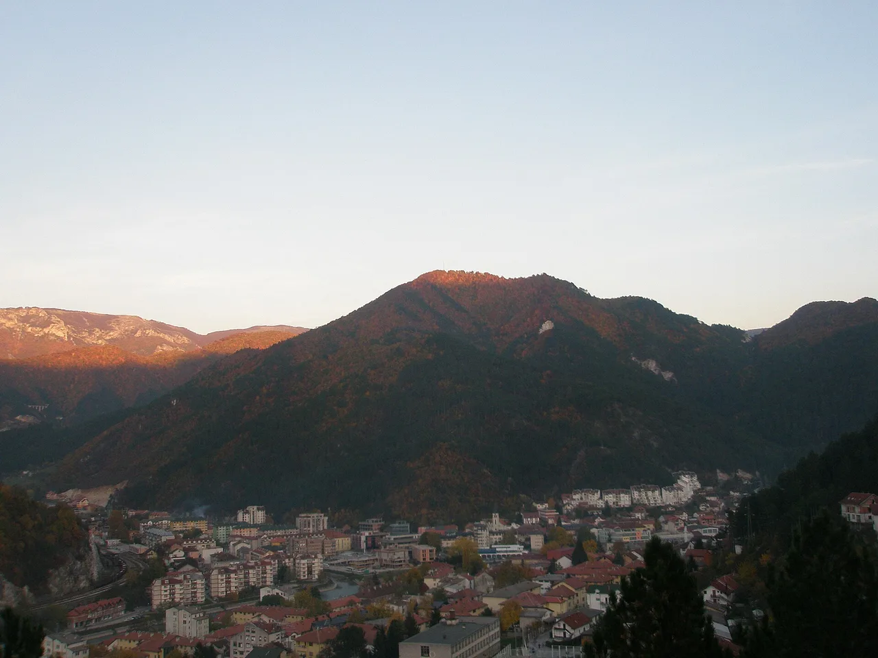 The mountains above Konjic glowing at dusk with the town and river in shadow in the valley below