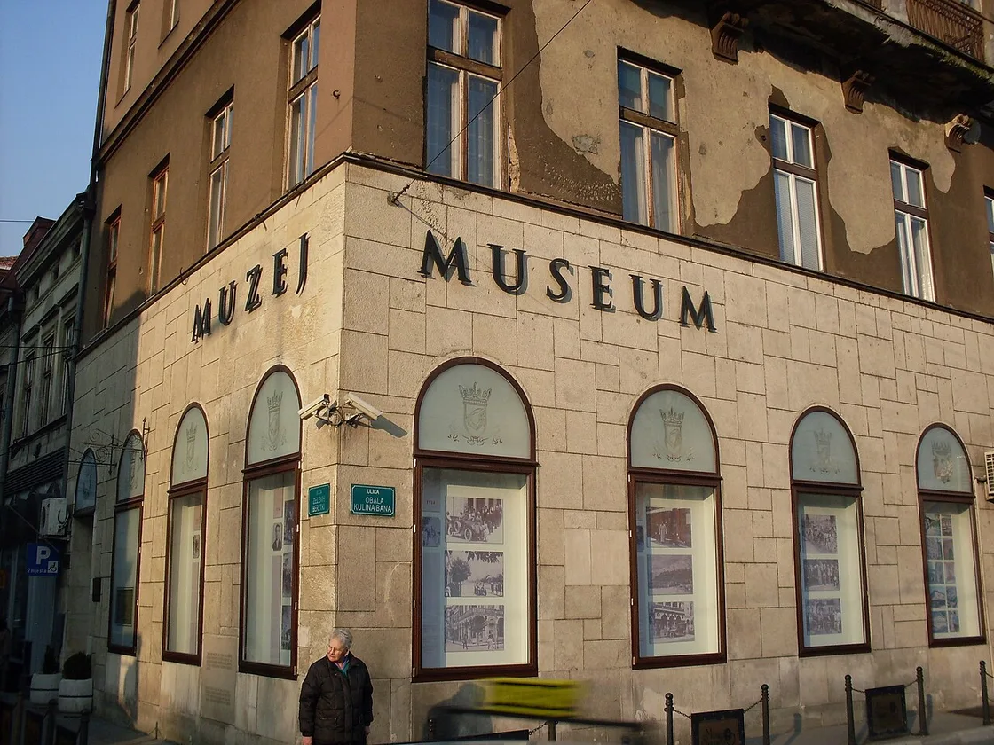 Close view of the stone corner facade of the Museum of Sarajevo 1878-1918, with MUZEJ MUSEUM lettering and the Obala Kulina bana street sign