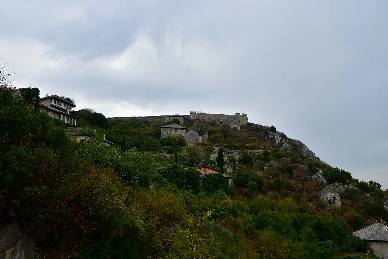 The hilltop stone fortress of Pocitelj rising above green terraces and old houses, a common stop on the road between the coast and Mostar