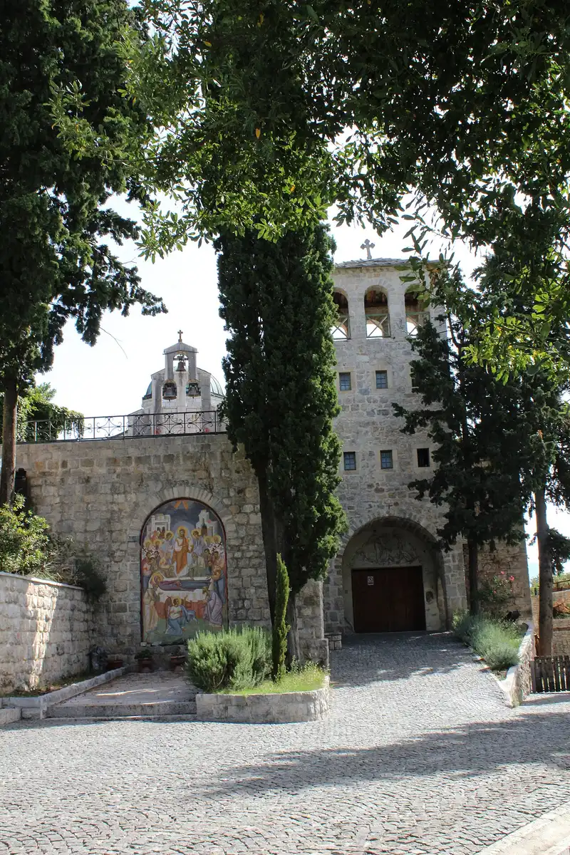 Bell tower, arched gate and wall mosaic at Tvrdoš Monastery near Trebinje
