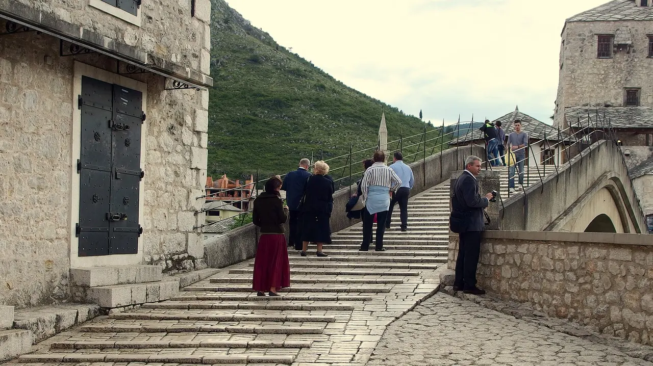 Visitors crossing the Ottoman stone arch of the Old Bridge in Mostar, the starting point of the trip to Kotor