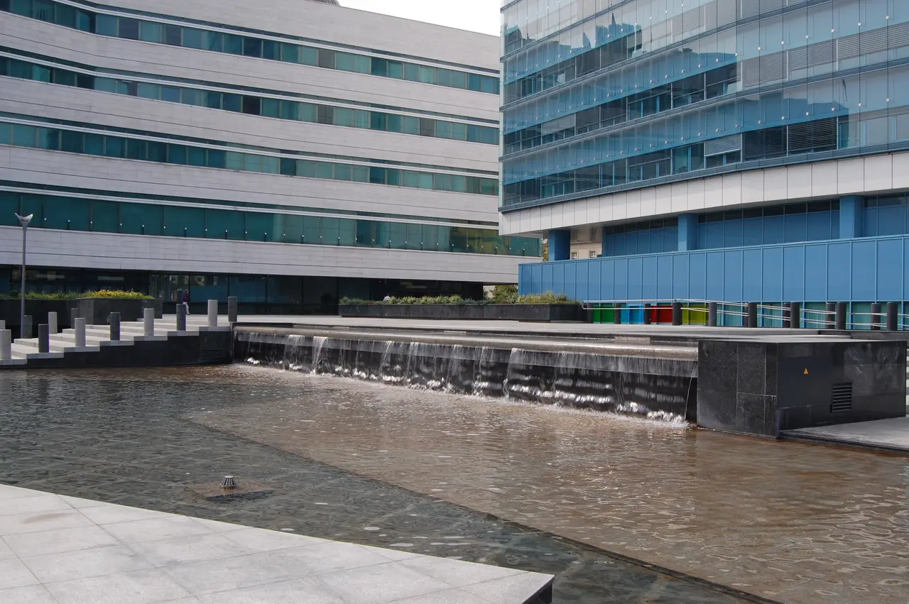 The glass and stone office blocks of the Parliamentary Assembly complex in central Sarajevo with a water cascade in front