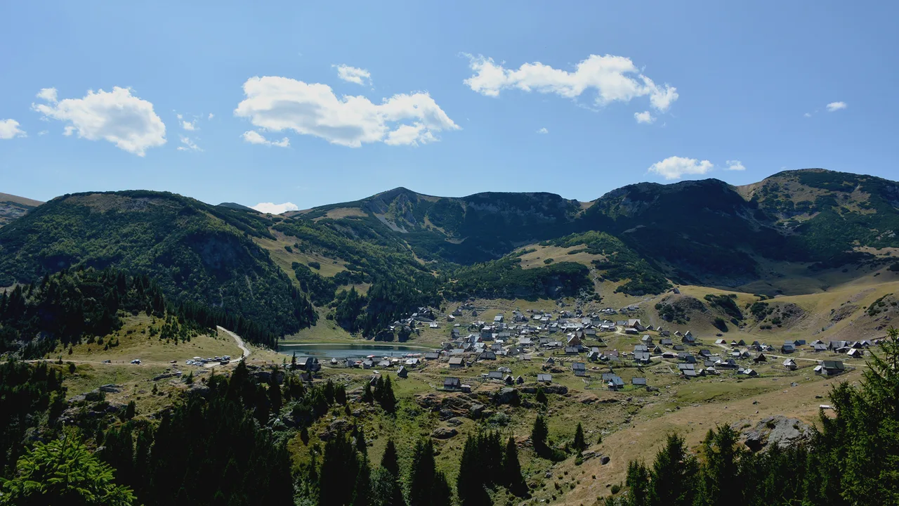 Prokoško Lake filling a high pasture bowl on Vranica with mountain ridges beyond the water