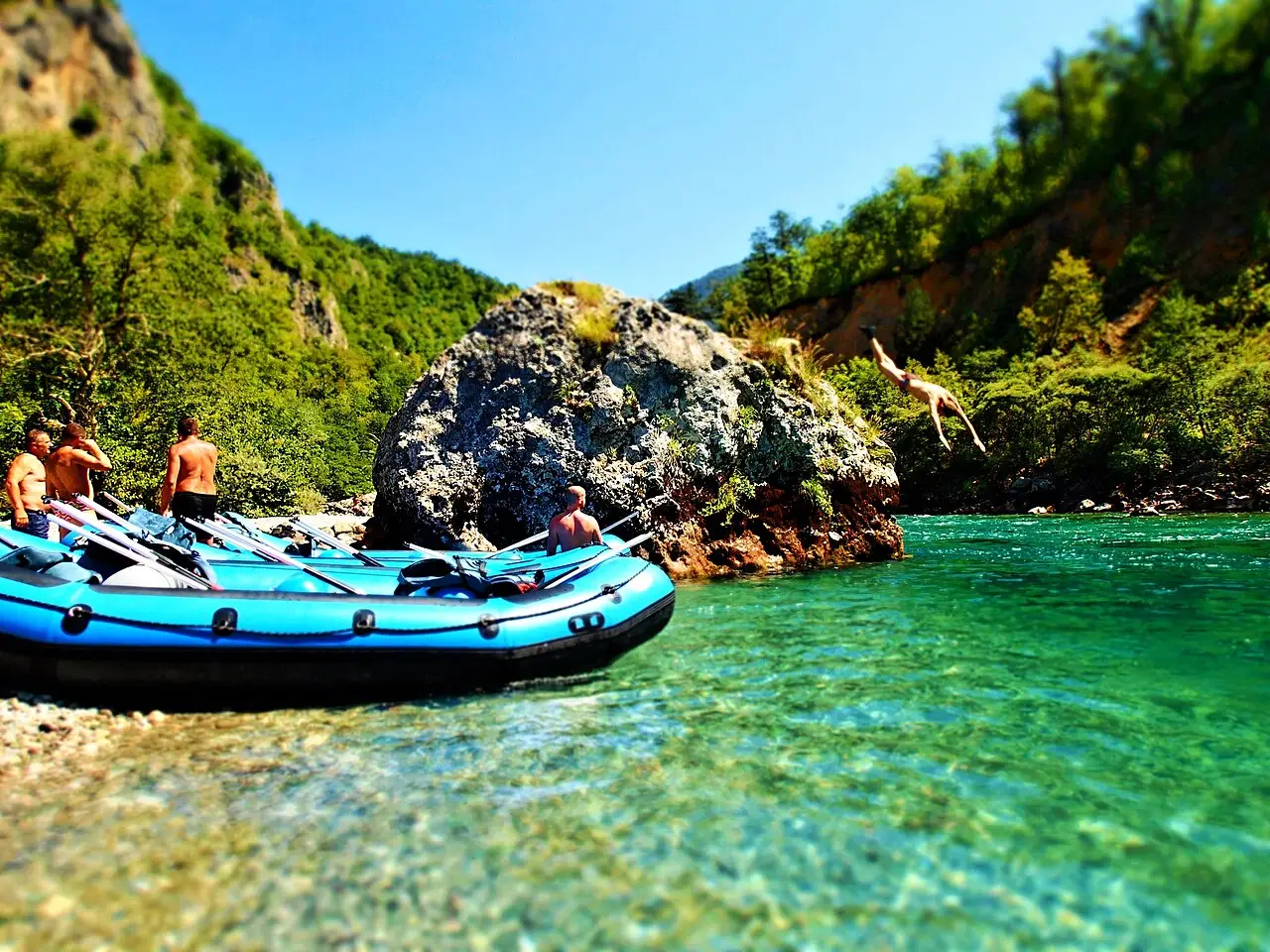 Rafters in the Tara canyon on the Bosnia-Montenegro border, paddling past a swimmer in the green water