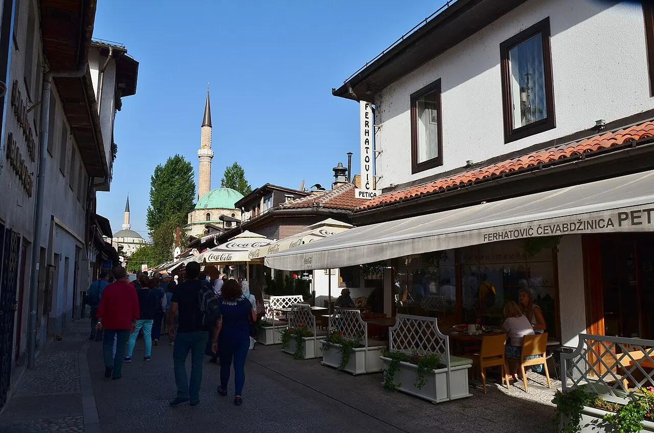 Bravadziluk street in Bascarsija, Sarajevo, with cafe terraces and a mosque minaret in the background