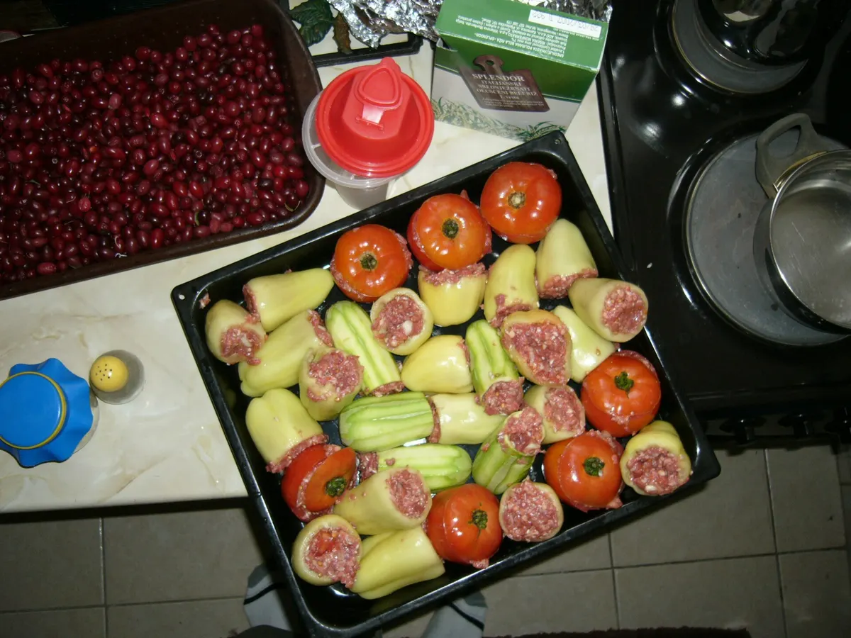 A baking dish of stuffed peppers in sauce, the kind of slow vegetable plate Food House lists on its vegetarian platter