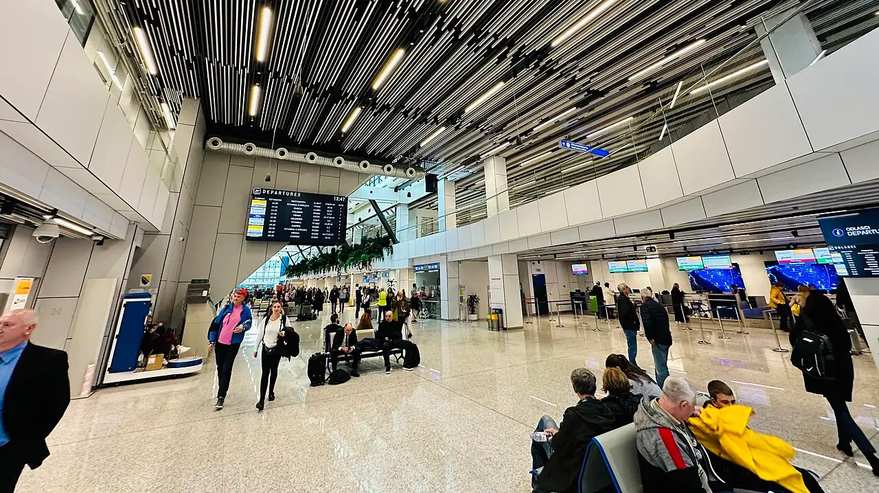 The modern departures hall of Sarajevo International Airport with the flight information board and passengers, the arrival gateway to the city