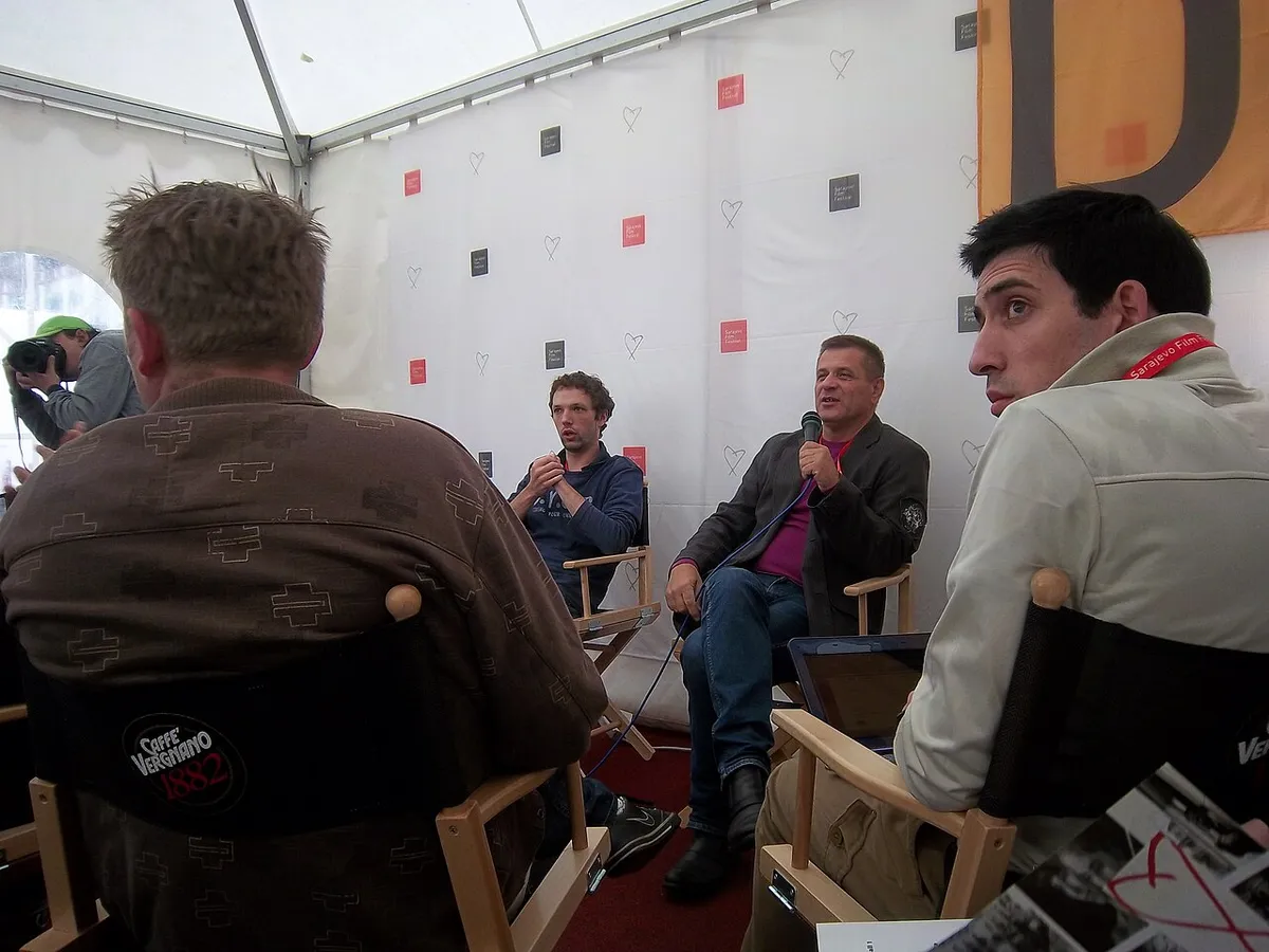 Filmmakers in directors chairs at a Q&A under a marquee with a Sarajevo Film Festival branded backdrop