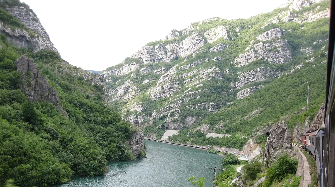 View from a train window of the Neretva river and green hills on the scenic line between Sarajevo and Mostar