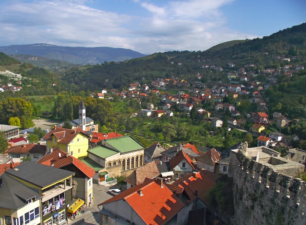 Jajce old town and the hillside suburbs seen from the fortress walls, green valley beyond