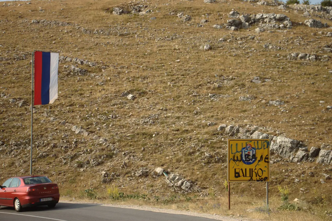 The two-lane approach road dropping into Gacko, a highland town on the Sarajevo to Trebinje corridor via Foča