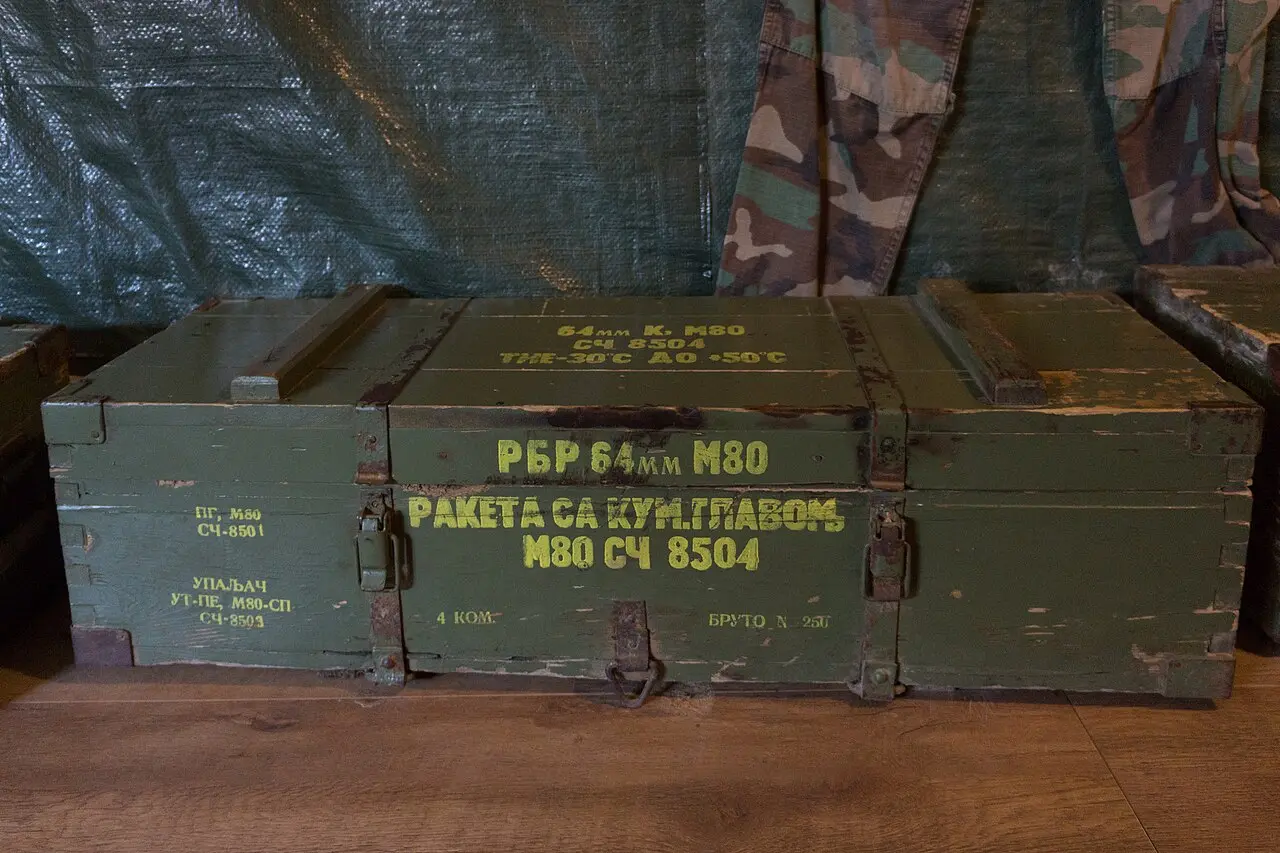 Wartime ammunition crates and a camouflage jacket displayed inside the Sarajevo War Tunnel museum