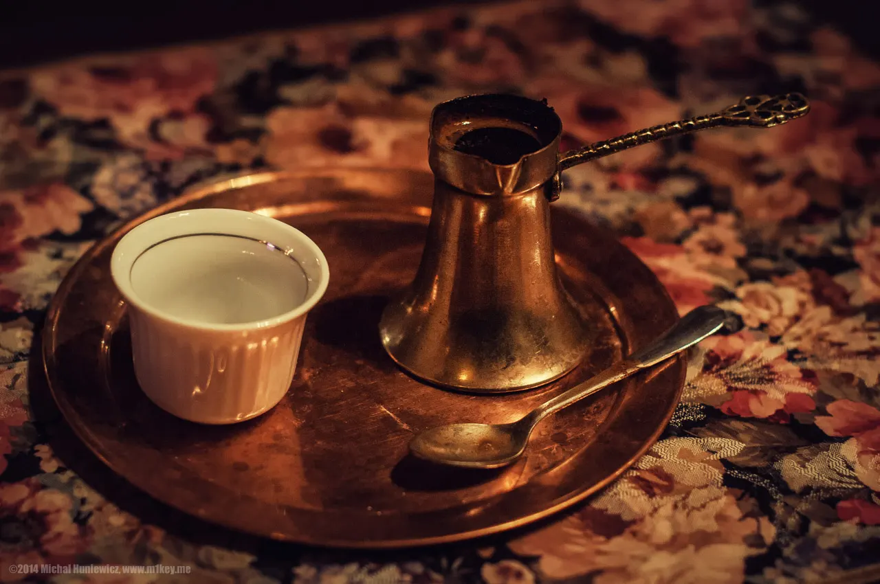 A copper džezva of Bosnian coffee with a small fildžan cup on a café table