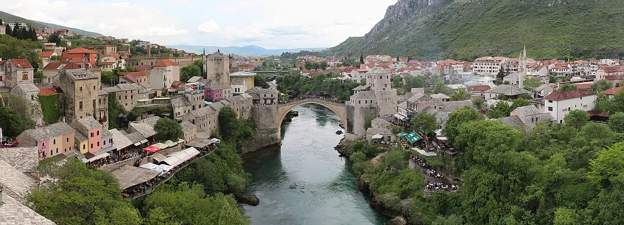 Panorama of Mostar with the Old Bridge over the Neretva and the old town below the mountains, the destination of the journey