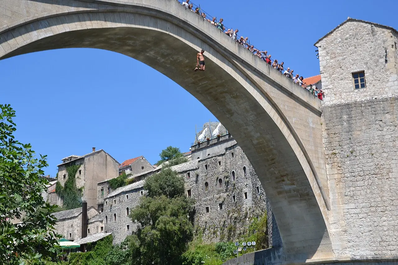 A local diver mid-leap from the parapet of Mostar's Old Bridge towards the Neretva far below