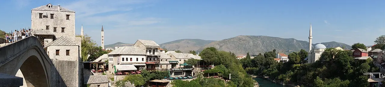 Wide panorama of Mostar with the Old Bridge, minarets and Ottoman houses along the Neretva
