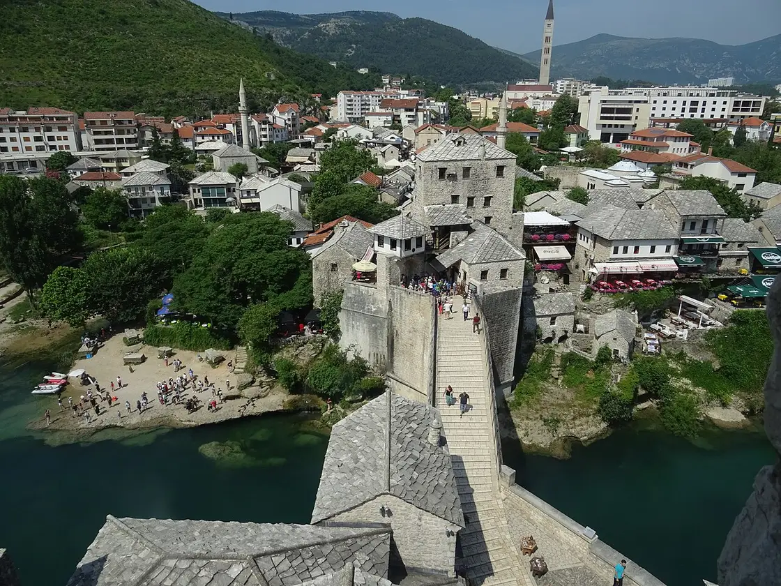 Stari Most, the Old Bridge of Mostar, seen across the Neretva with stone houses on the far bank